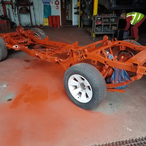 Vehicle chassis painted orange after blasting