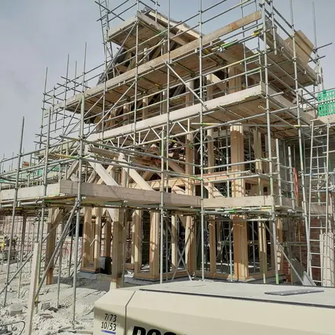 Green oak frame building under scaffold