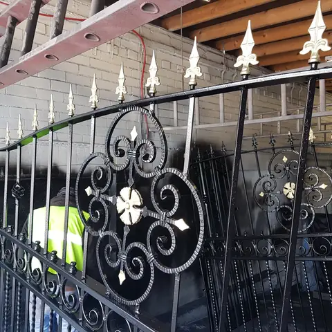 Iron gates painted black with gold finials