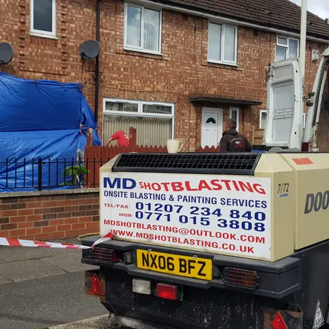 Mobile compressor outside house for brick cleaning
