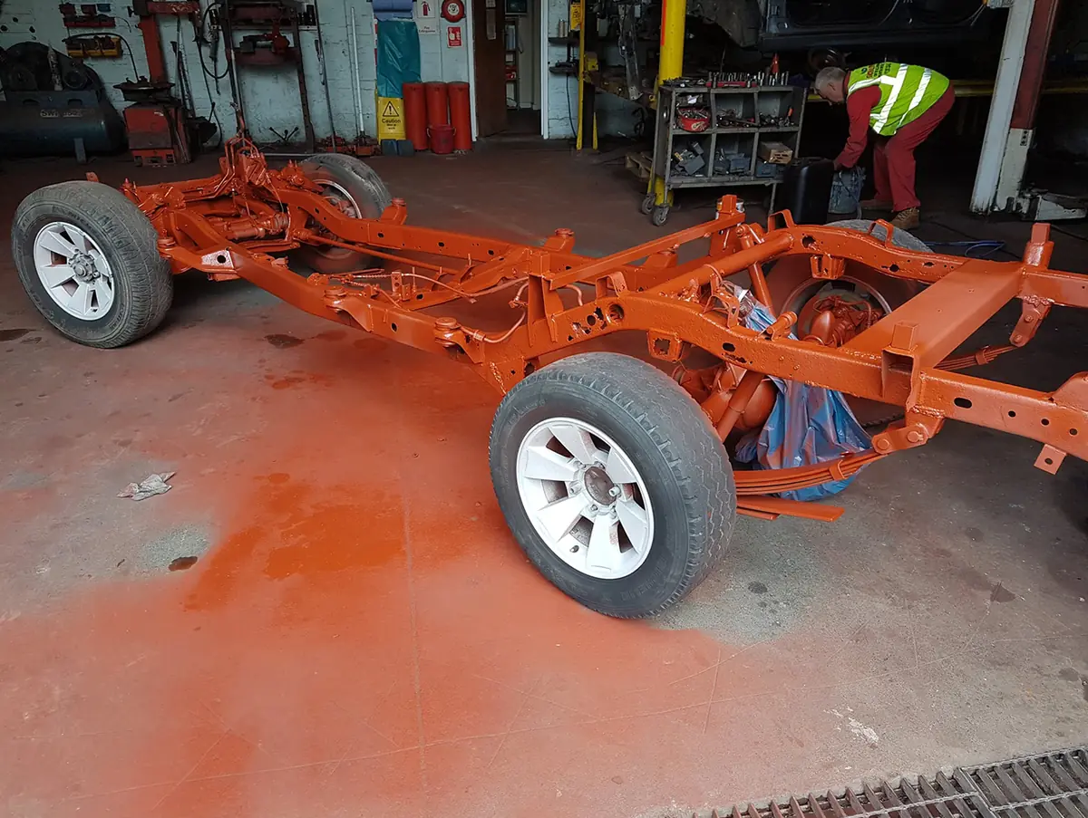 Vehicle chassis after shot blasting and painting orange